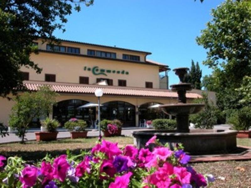 ein Gebäude mit einem Brunnen in einem Park mit Blumen in der Unterkunft Residence Hotel La Commenda in Montefiascone