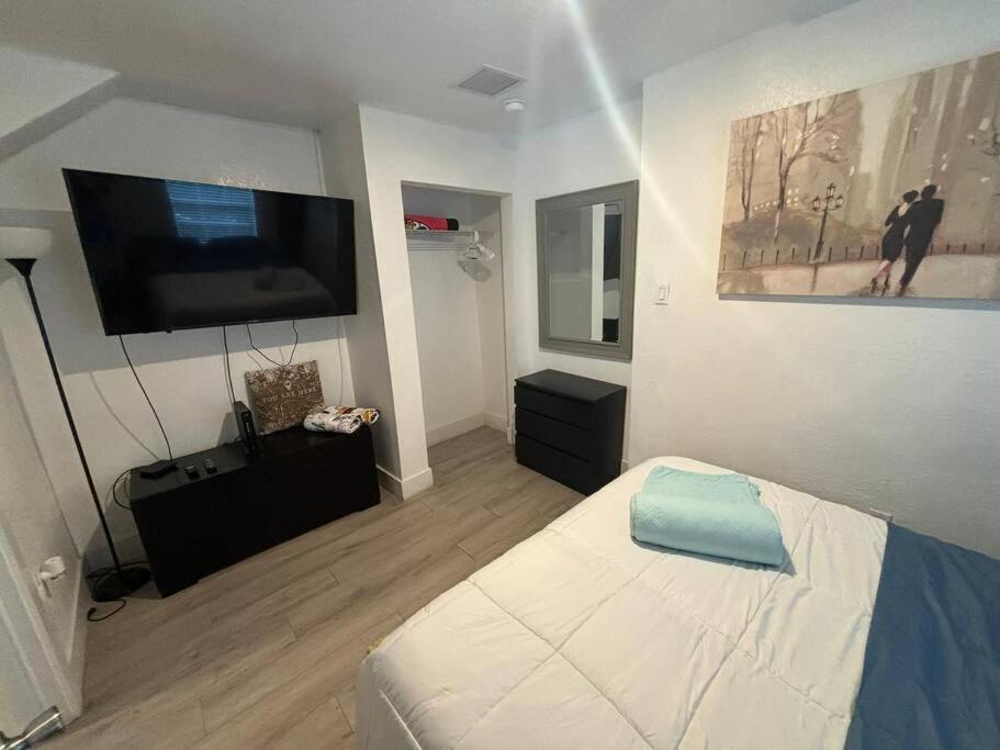 una camera con letto e TV a schermo piatto di Quiet & Centrally located House - PRIVATE PARKING, LAUNDRY AND STORAGE FOR LUGGAGE a Miami
