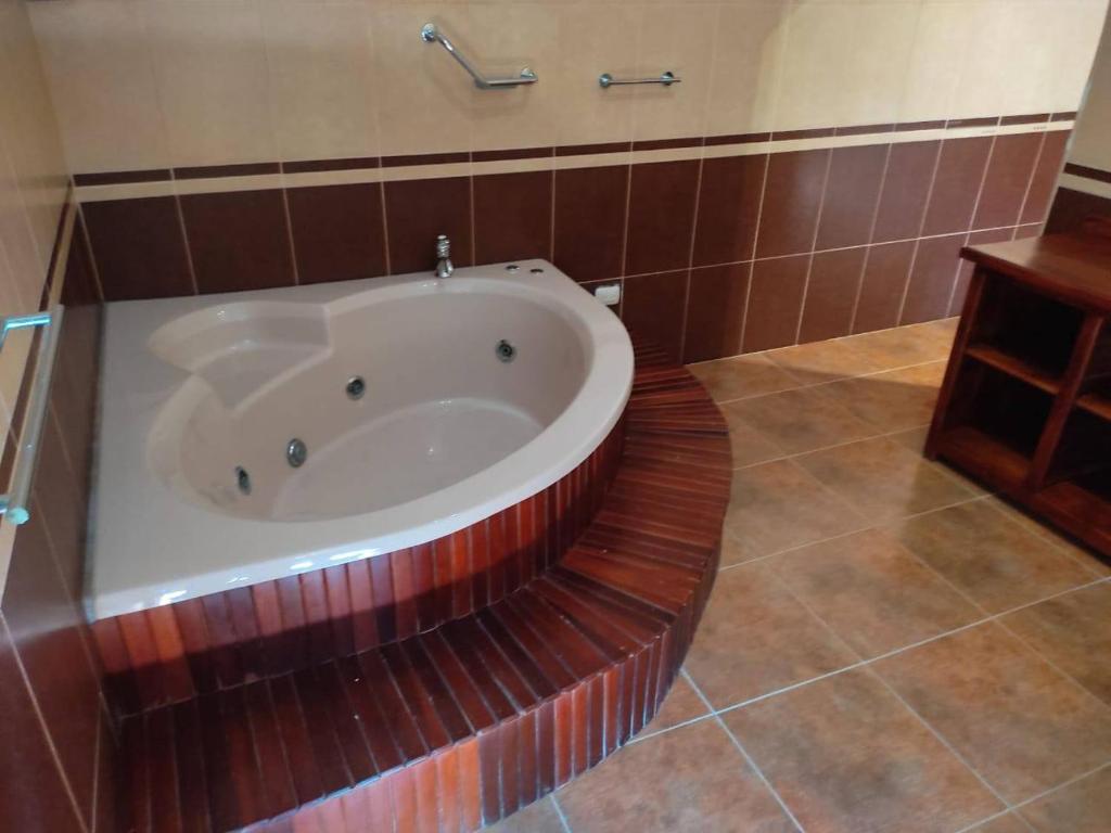 リオ・サン・ファンにあるVilla piscina naturalの茶色のタイル張りのバスルーム(バスタブ付)