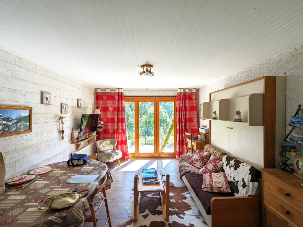 un salon avec un canapé et une table dans l'établissement Appartement 6 pers, proche pistes, terrasse et parking inclus à La Clusaz - FR-1-459-217, à La Clusaz
