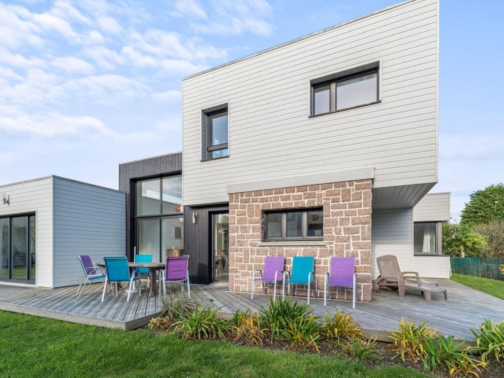 a house with purple and blue chairs on a deck at Villa lumineuse 4 étoiles, 50m de la plage, jardin clos, tranquillité à Trégastel - FR-1-368-399 in Trégastel
