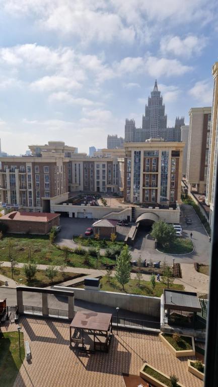 Blick auf eine Stadt mit Park und Gebäuden in der Unterkunft Стильная квартира в ЖК бизнес класса AVENUE 5 in Astana