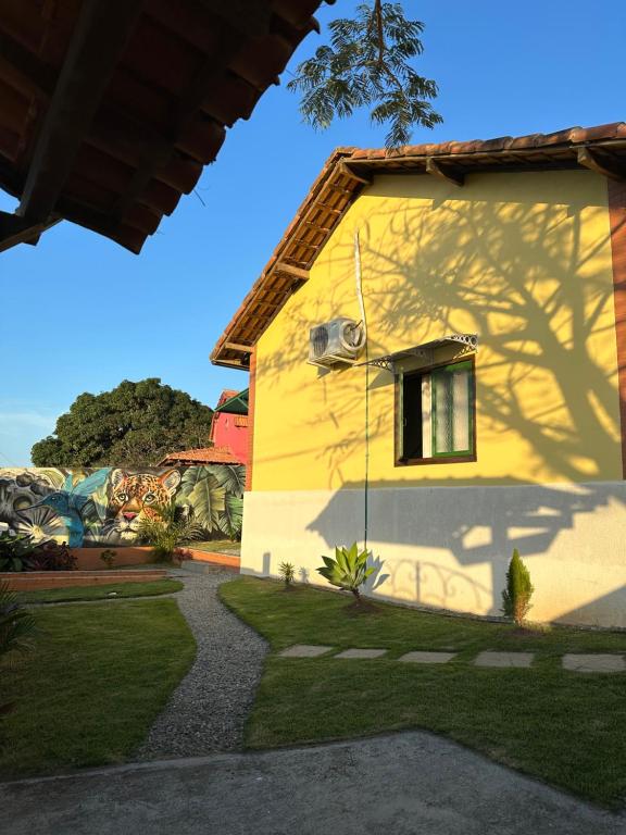 une maison jaune à l'ombre d'un arbre dans l'établissement By Búzios Loft, à Búzios