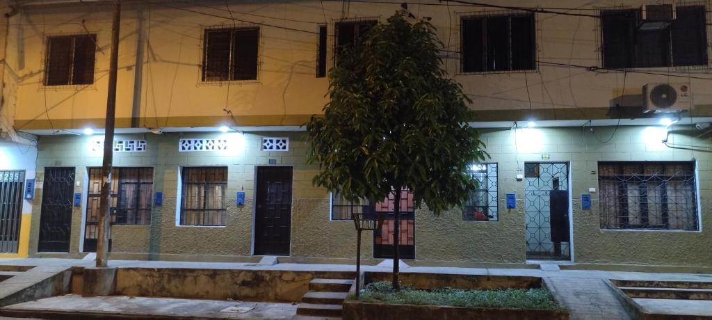 a building with a tree in front of it at Mini Departamento Iquitos 1243 in Iquitos