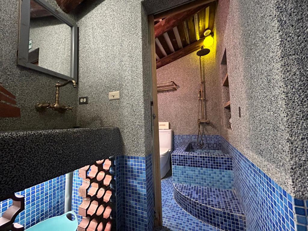 安平的住宿－緩緩歸 Slow living，浴室的墙壁上铺有蓝色瓷砖,设有水槽。
