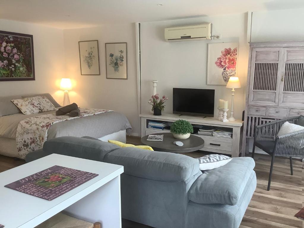 Petite Provence Cottage في بليرغوري: غرفة معيشة مع أريكة وسرير