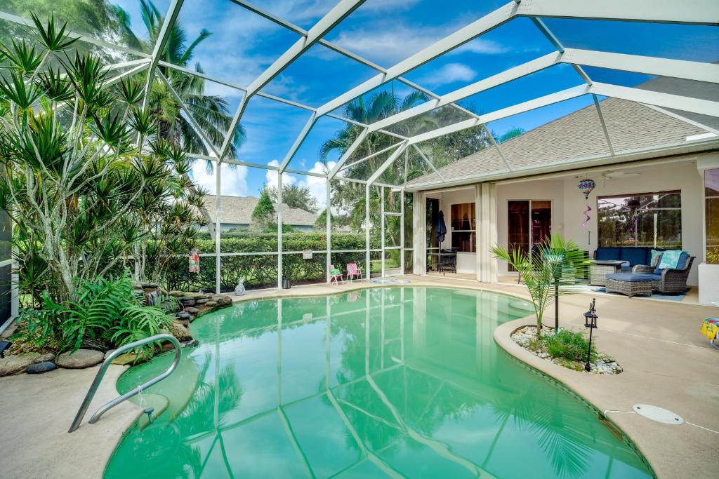 a swimming pool in a house with a glass ceiling at Ranch-Style Florida Retreat with Pool and Lanai in Merritt Island