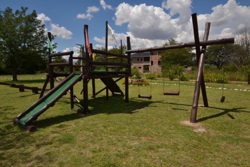 an empty playground with a slide in the grass at Viejo Molino in Nono