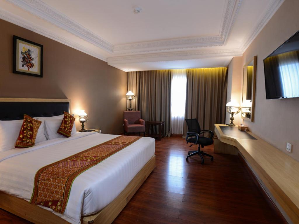 Postel nebo postele na pokoji v ubytování The Rich Jogja Hotel