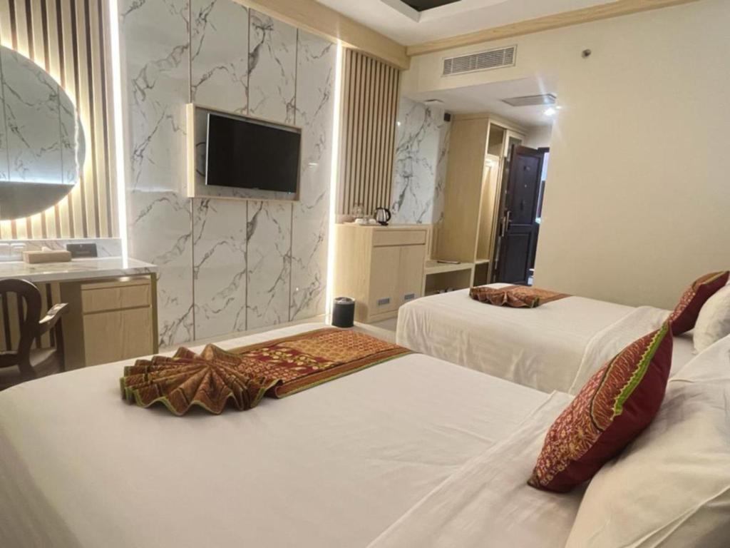 Postel nebo postele na pokoji v ubytování The Rich Jogja Hotel