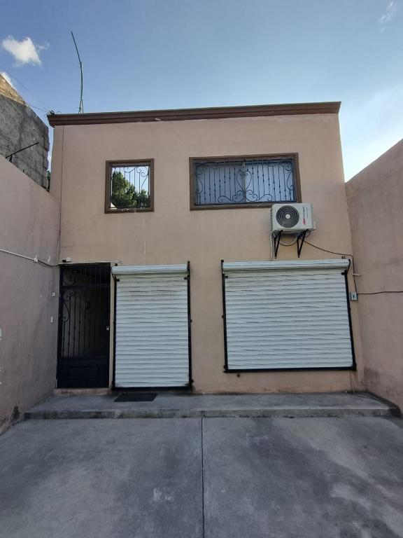 a building with two garage doors and a fan at Departamento Victoria in Saltillo