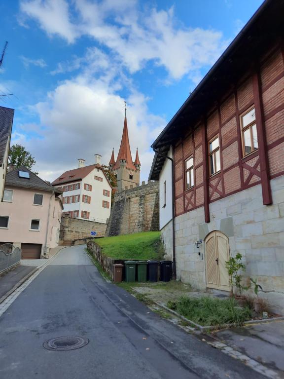 una strada vuota con un edificio e un castello di Schlossblick Heroldsberg a Heroldsberg