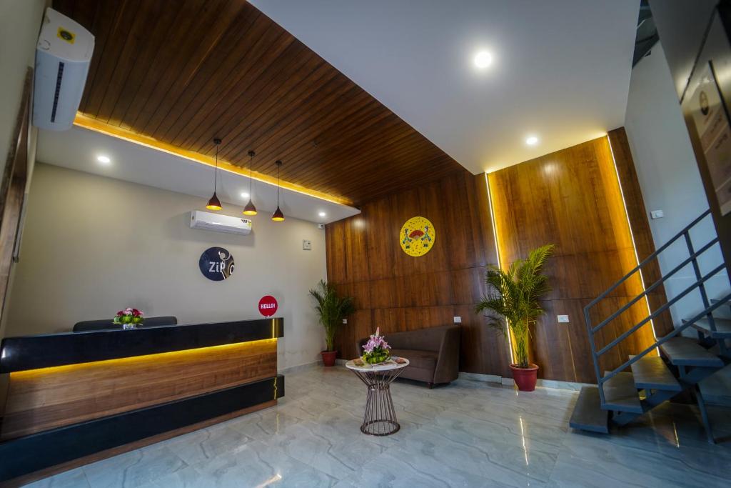 a lobby with a reception desk and a table at Zip By Spree Hotels Bhopal in Bhopal