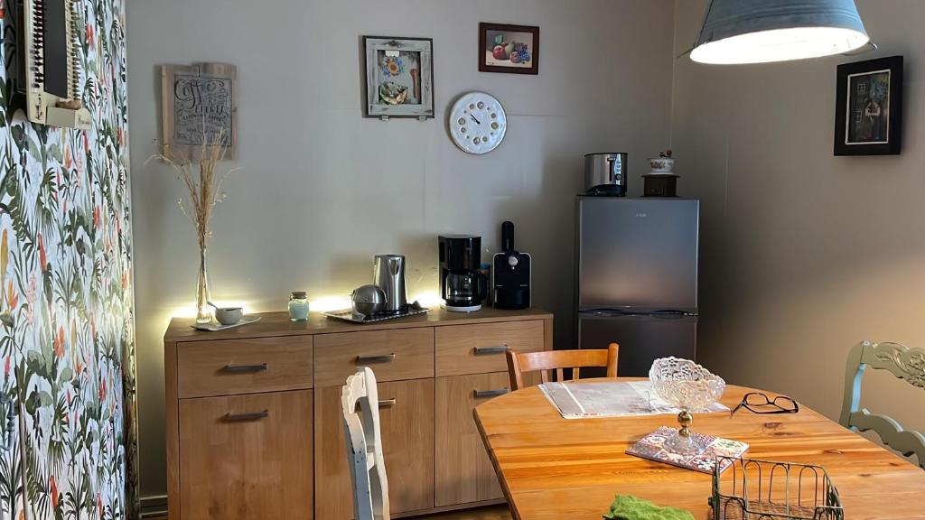 cocina con mesa de madera y nevera en appartement Vintage a l ancienne forge en Muhlbach-sur-Munster