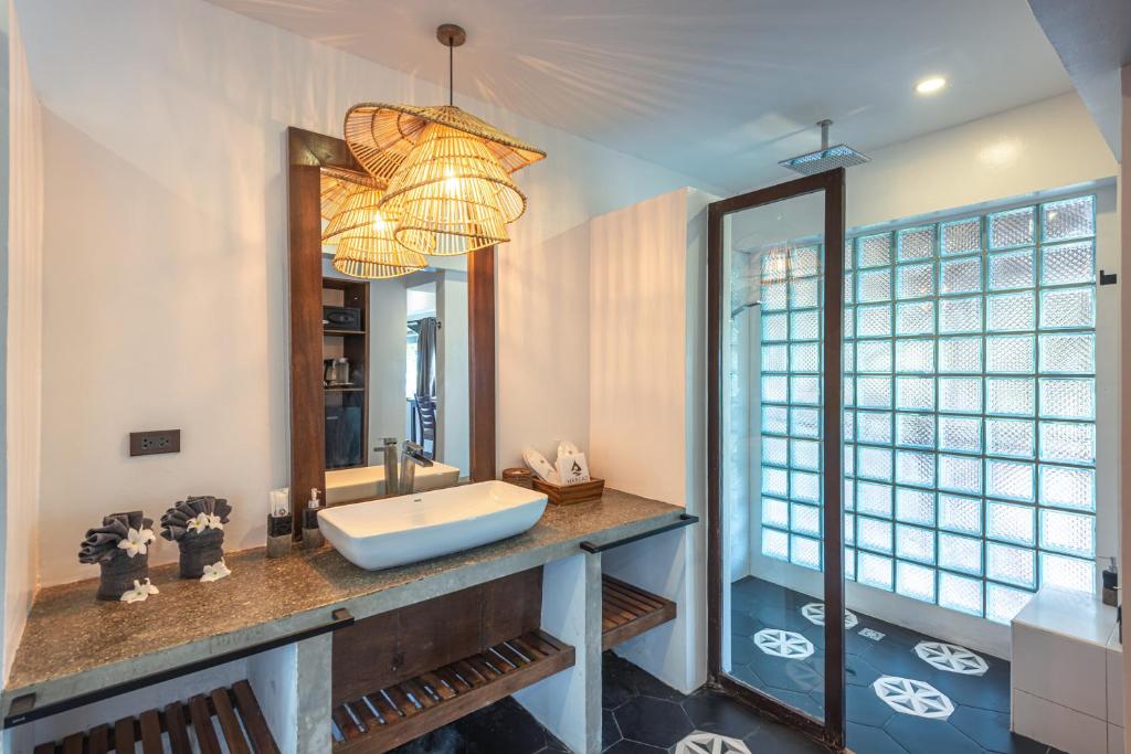 a bathroom with a sink and a large mirror at Siargao Island Villas in General Luna