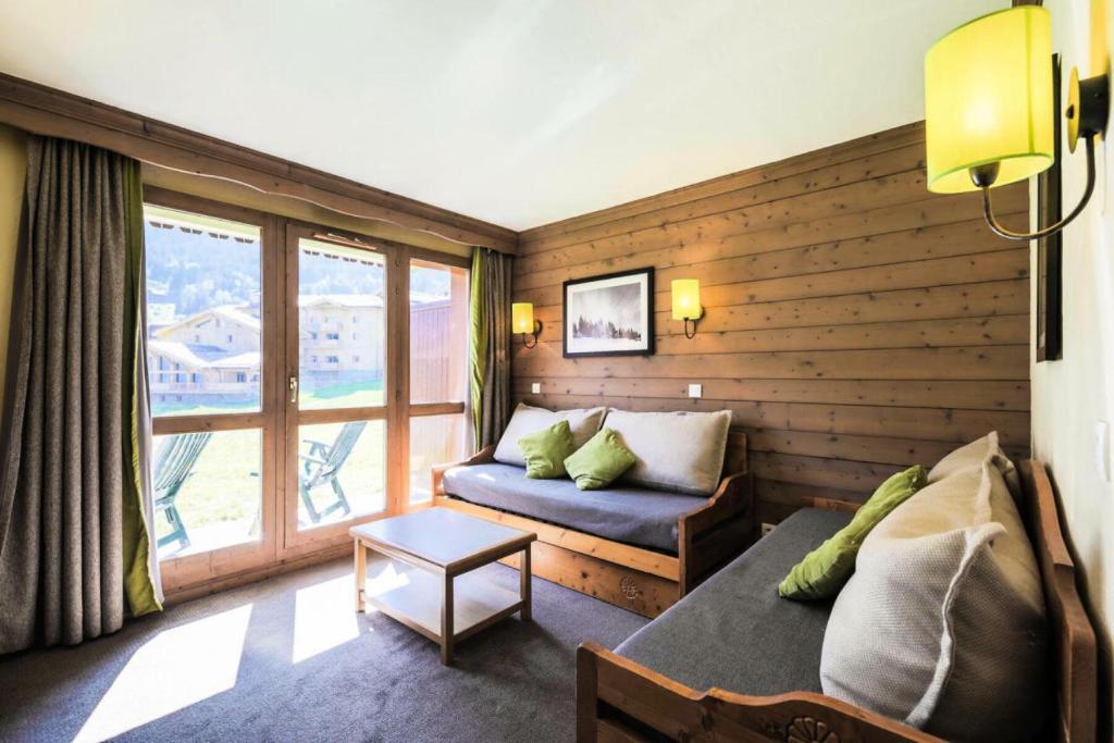 un salon avec un canapé et une fenêtre dans l'établissement Quartier La Forêt - maeva Home - Appartement 2 pièces 6 personnes - Sélection MAE-6114, à Valmorel