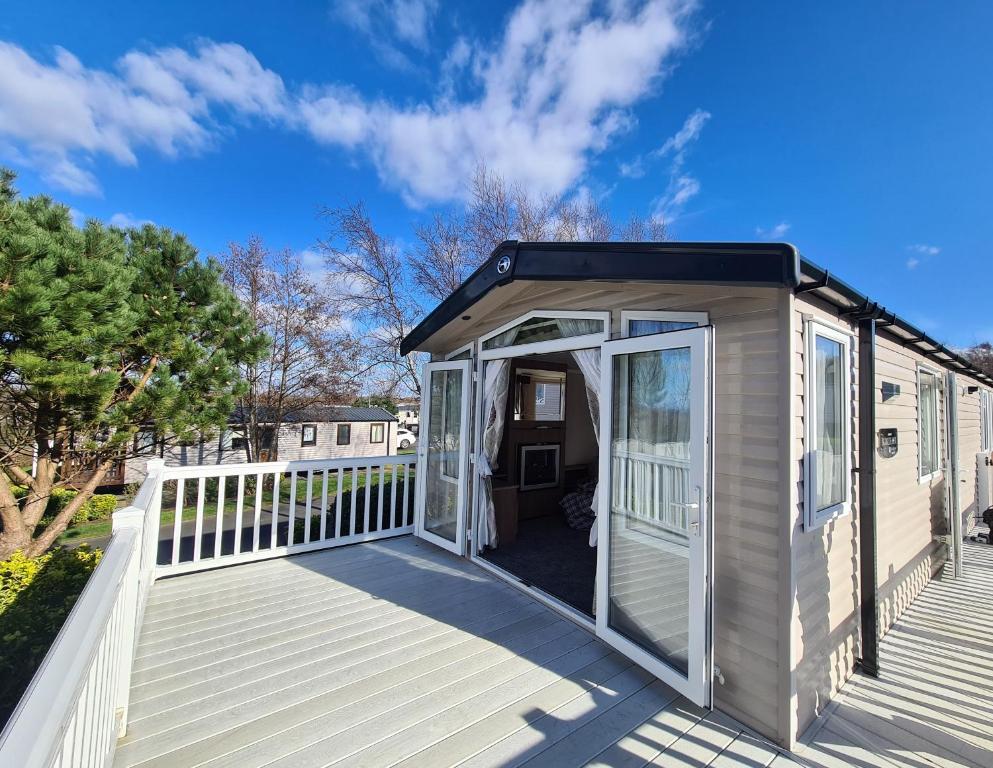 a tiny house with a porch and a deck at 6 St Andrews- Craig Tara in Ayr