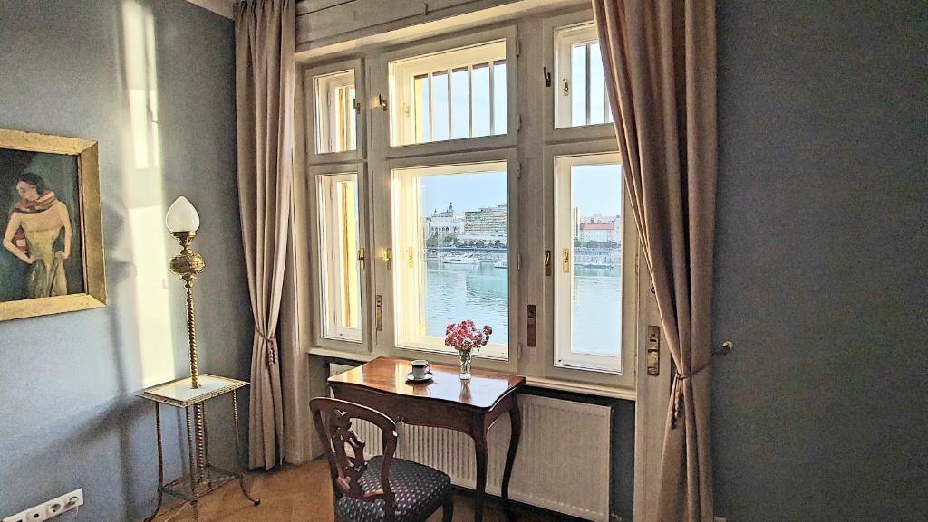 una habitación con una ventana y una mesa con flores. en Schieszl Apartments 2, en Budapest