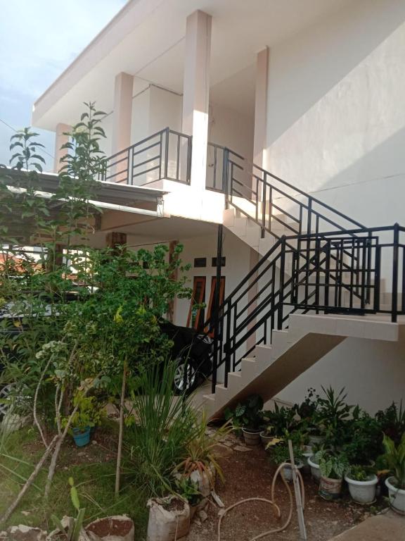 a building with a staircase and some plants at Sibento Komodo Homestay in Labuan Bajo