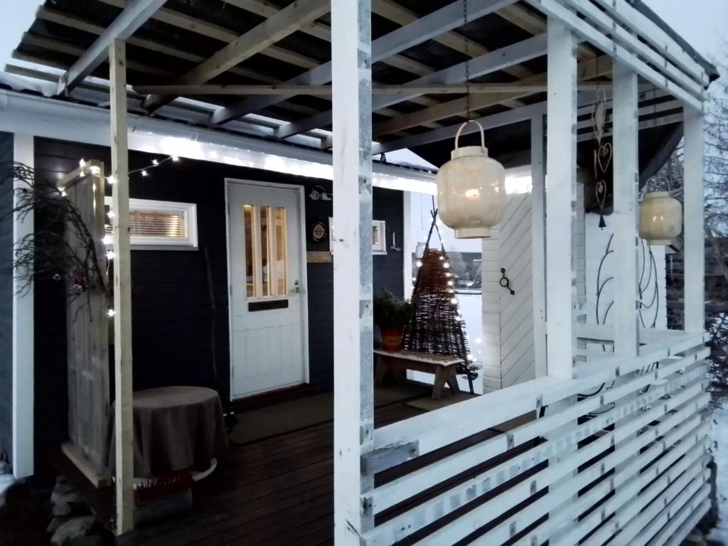 a porch with a white door and a christmas tree at Experience accommadation Eco-Unela in Rovaniemi