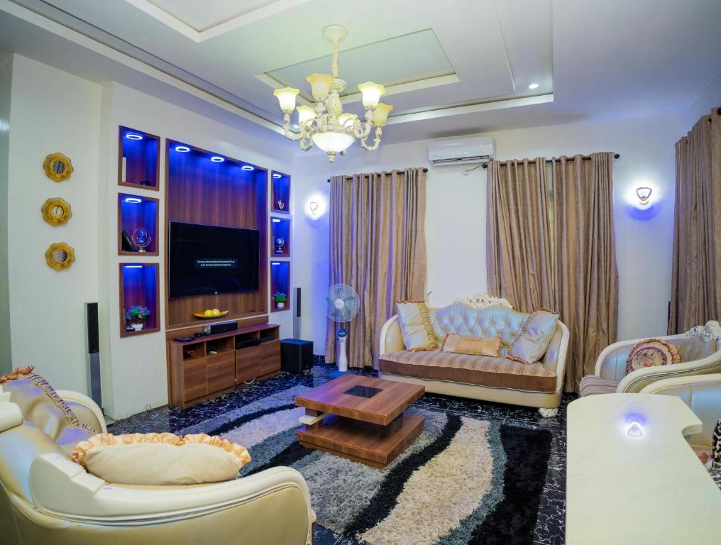 a living room with two couches and a tv at Luxury 4 bedroom duplex in Lekki