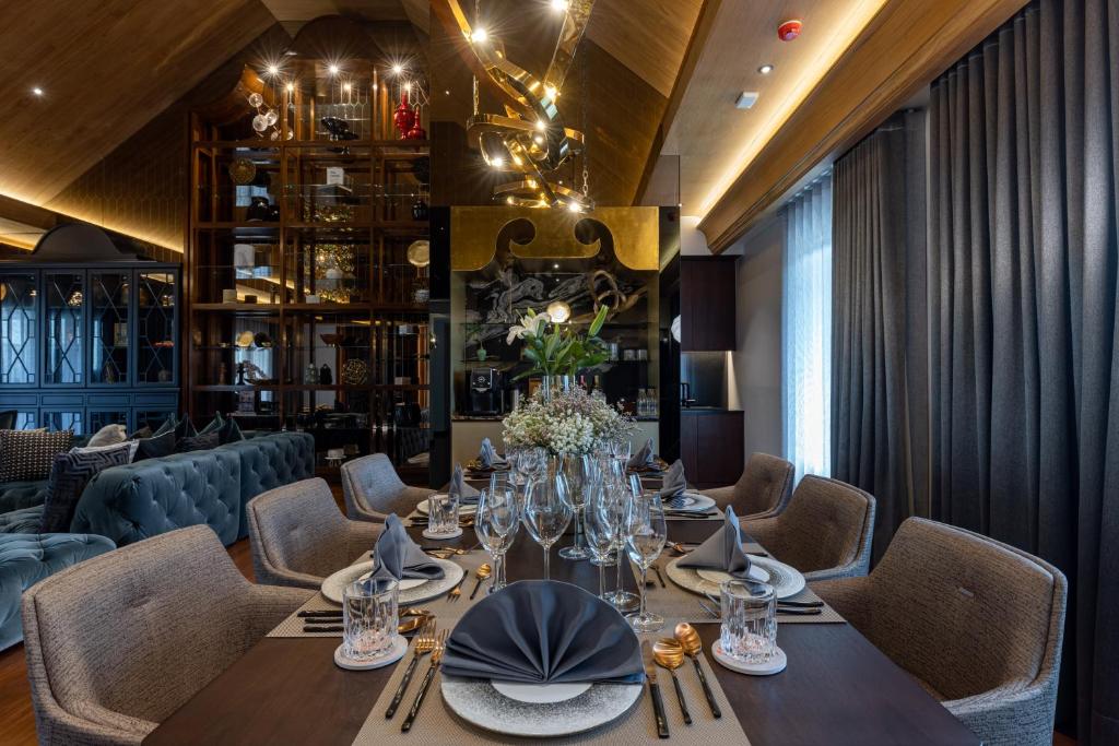 A formally set dining table in an intimate, dark-wood restaurant setting.