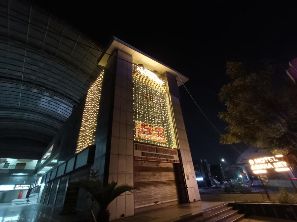 a building with a sign on it at night at HOTEL ASIANA SKY Motera Ahmedabad in Ahmedabad