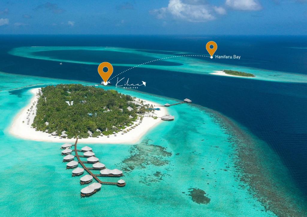 a small island with boats in the water at Kihaa Maldives in Baa Atoll