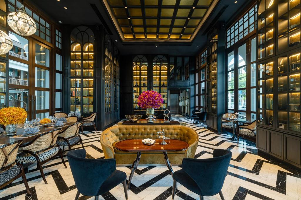 A richly decorated lounge with a curved sofa, reading tables, and display cabinets.