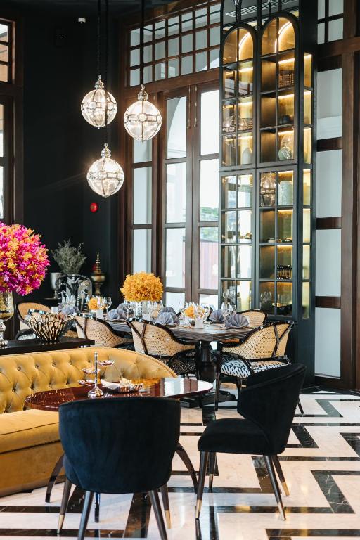 A formal restaurant seating area with pendant lights and a tufted sofa.