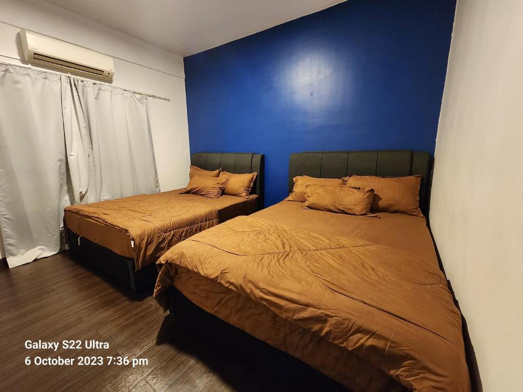 2 camas en un dormitorio con una pared azul en Dream Home (Marina View Villas), en Port Dickson