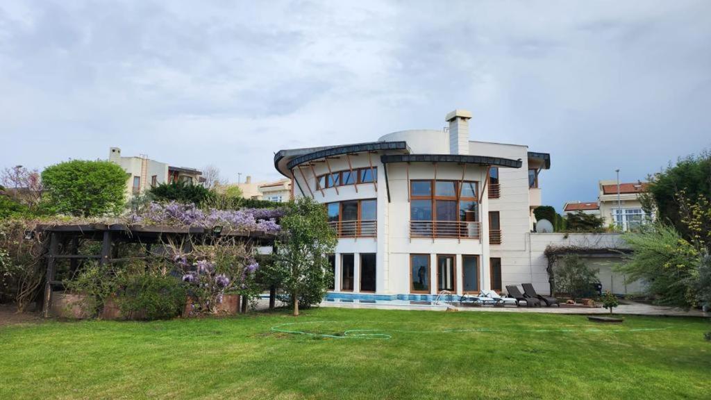 una gran casa blanca con césped delante en Lux villla near cntr with view pool beach accss, en Sarıyer