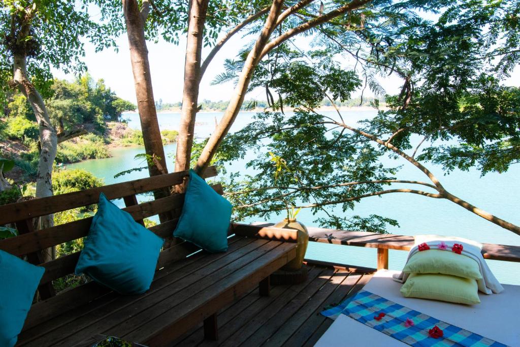a bench on a deck with a view of the water at Mekong Bird Resort & Hotel in Stœ̆ng Trêng