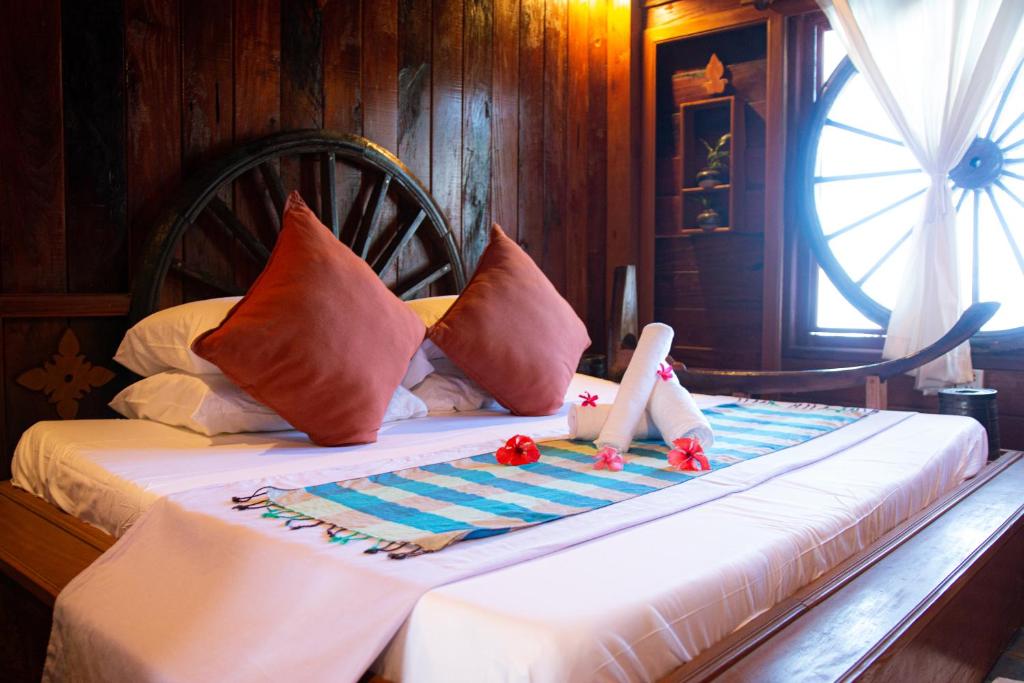 a bedroom with a bed with towels and flowers on it at Mekong Bird Resort & Hotel in Stœ̆ng Trêng