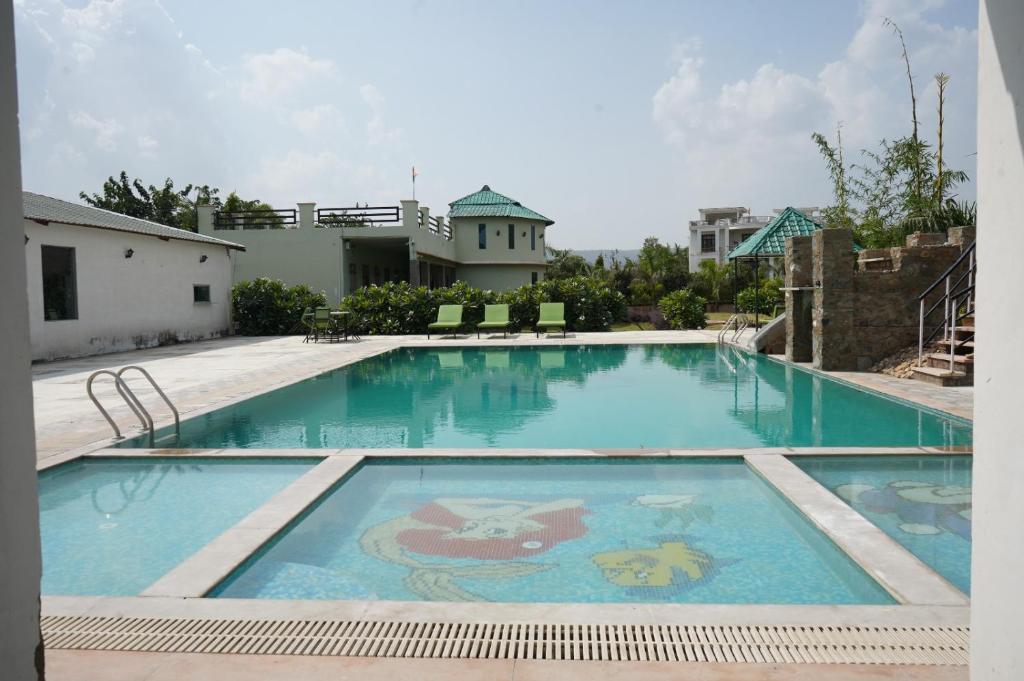 a large swimming pool with a painting on it at GREEN VALLEY SARISKA in Tehla