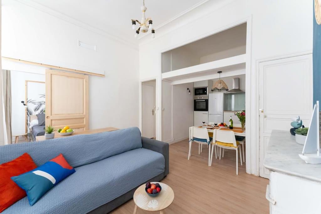 un salon avec un canapé bleu et une cuisine dans l'établissement Escapade marseillaise près des Terrasses du Port, à Marseille