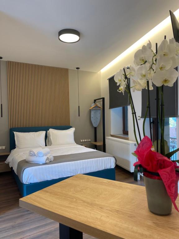 een hotelkamer met een bed en een tafel met bloemen bij 11 Luxury apartments. in Metsovo