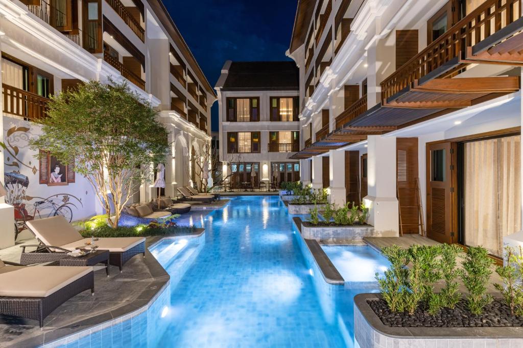 une image d'une piscine d'hôtel la nuit dans l'établissement Hotel Sensai Nimman Chiang Mai - Adults Only, à Chiang Mai