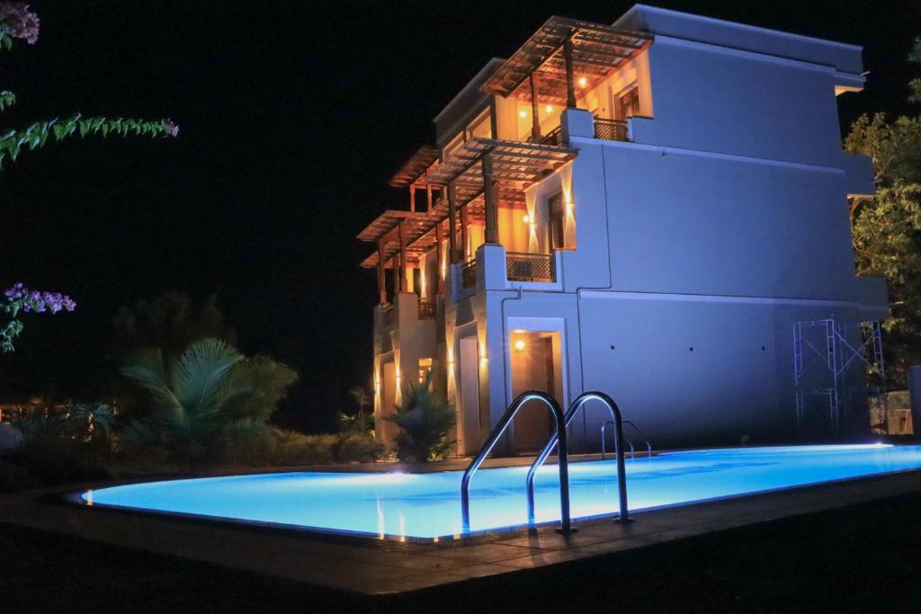 a swimming pool in front of a house at night at Paddyway Resort in Arugam Bay