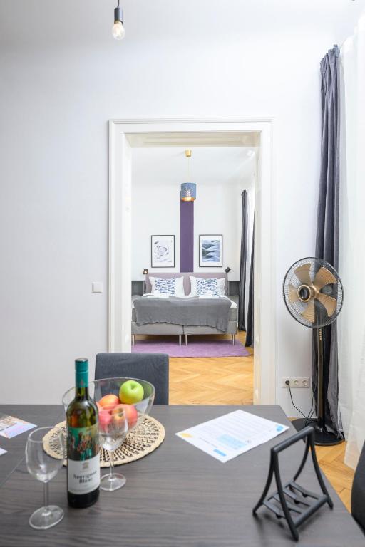 a table with a bottle of wine and a living room at Central City Apartments in Vienna
