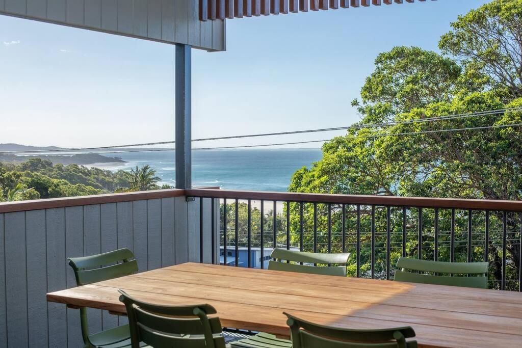 een houten tafel en stoelen op een balkon met uitzicht op de oceaan bij Float on Cylinder - 180 Degree Ocean Views in Point Lookout