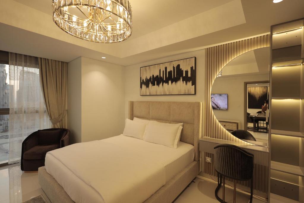 Schlafzimmer mit einem Bett und einem Kronleuchter in der Unterkunft PTR 3001-Lovely 1 Bedroom in Paramount Midtown in Dubai