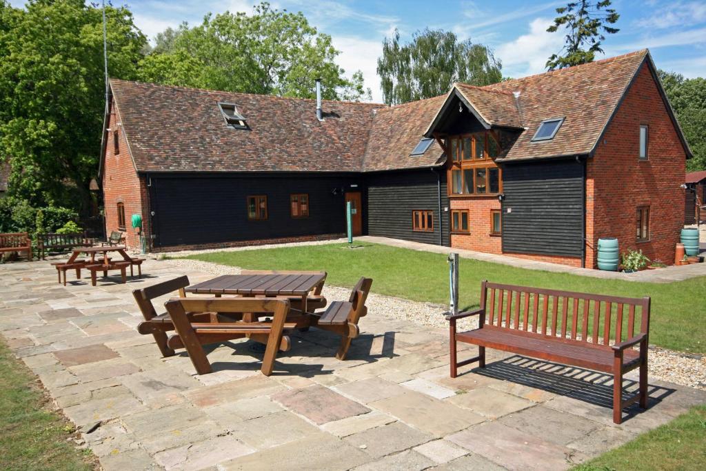 a picnic table and benches in front of a building at Upper Neatham Mill in Alton