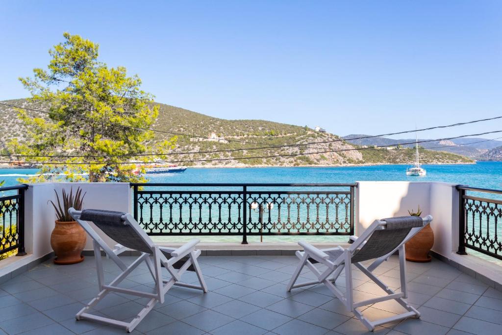 two chairs on a balcony with a view of the water at Vasilis Apartments Beachfront in Ermioni