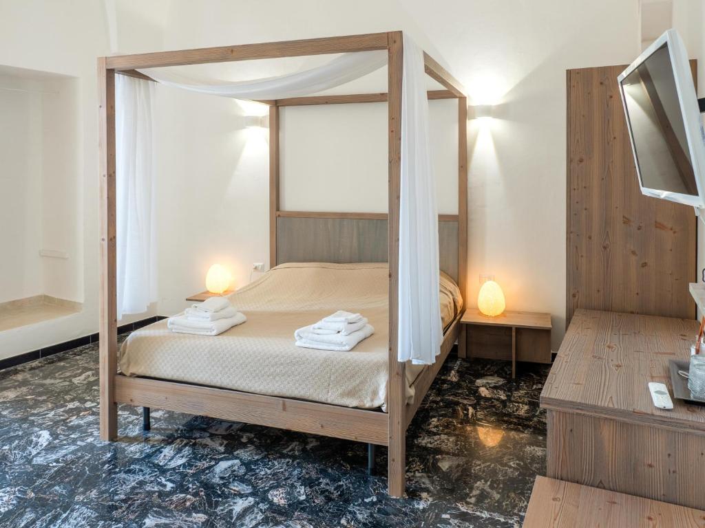 a bedroom with a bed with a canopy at Lucente Rooms & Suites in Ugento
