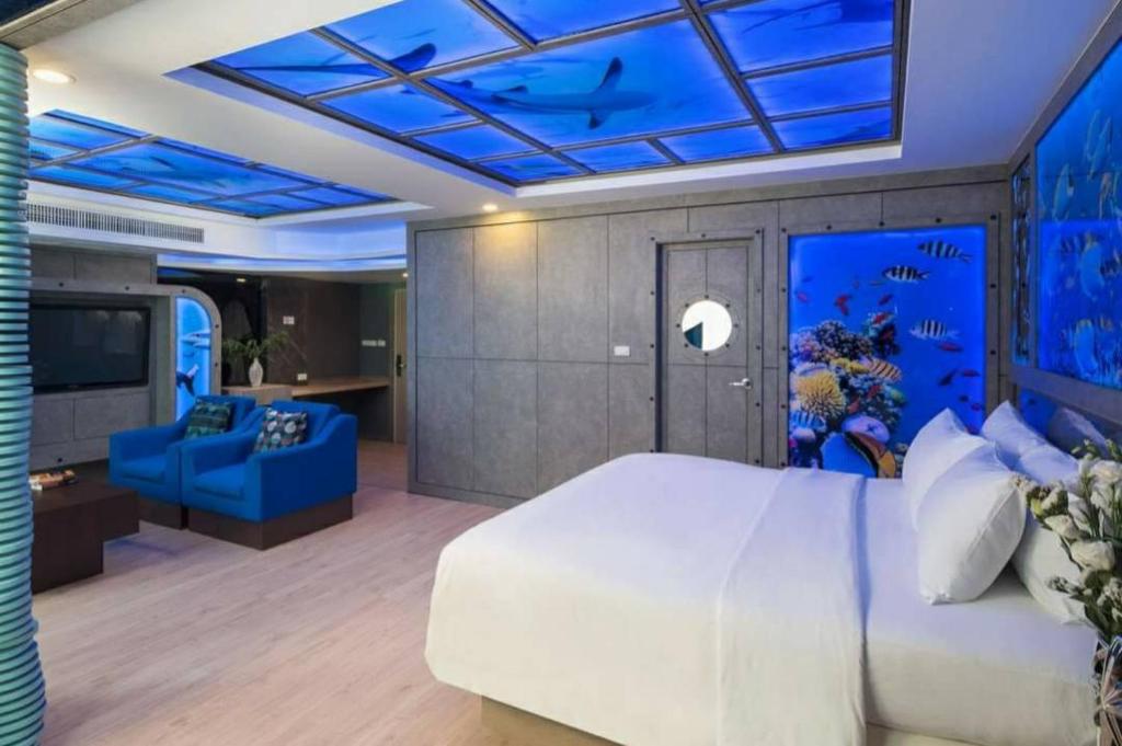 a bedroom with a large white bed and a blue ceiling at Rodina Beach Hotel in Jomtien Beach