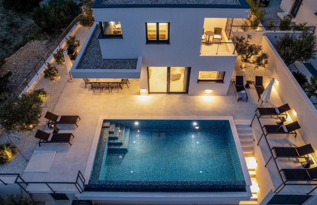 - une vue aérienne sur une maison avec une piscine dans l'établissement NEW! Stylish Villa Olea with heated pool and panoramic sea views, à Podstrana