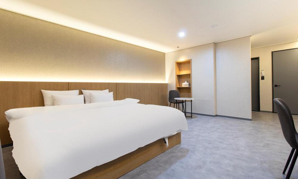 a large white bed in a hotel room at Hwaseong Stay13 Hotel in Hwaseong