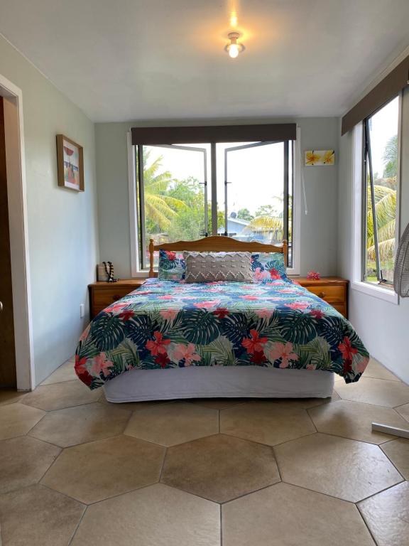 a bedroom with a bed with a colorful comforter at David's Fale, Alofi, Niue in Alofi