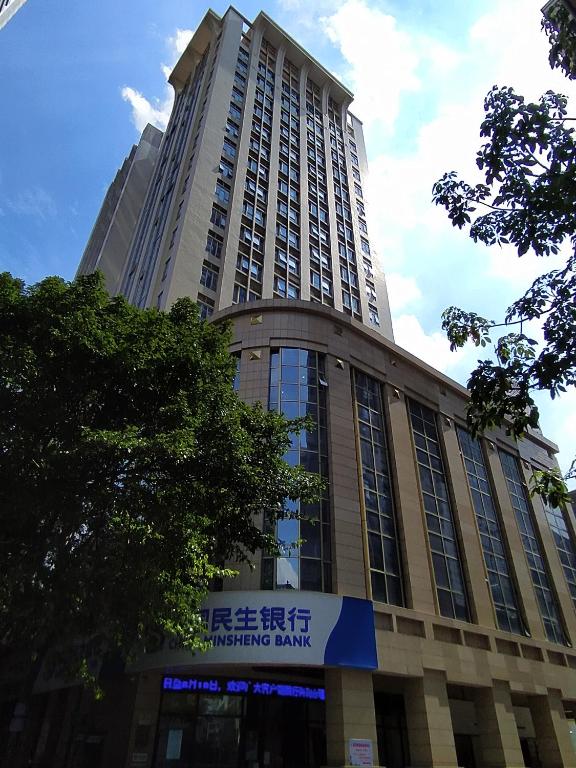 a tall building with a sign in front of it at WAIFIDEN Duplex Hotel Apartment Zhongyong Jinyu Branch-Free shuttle bus during the Canton Fair in Guangzhou